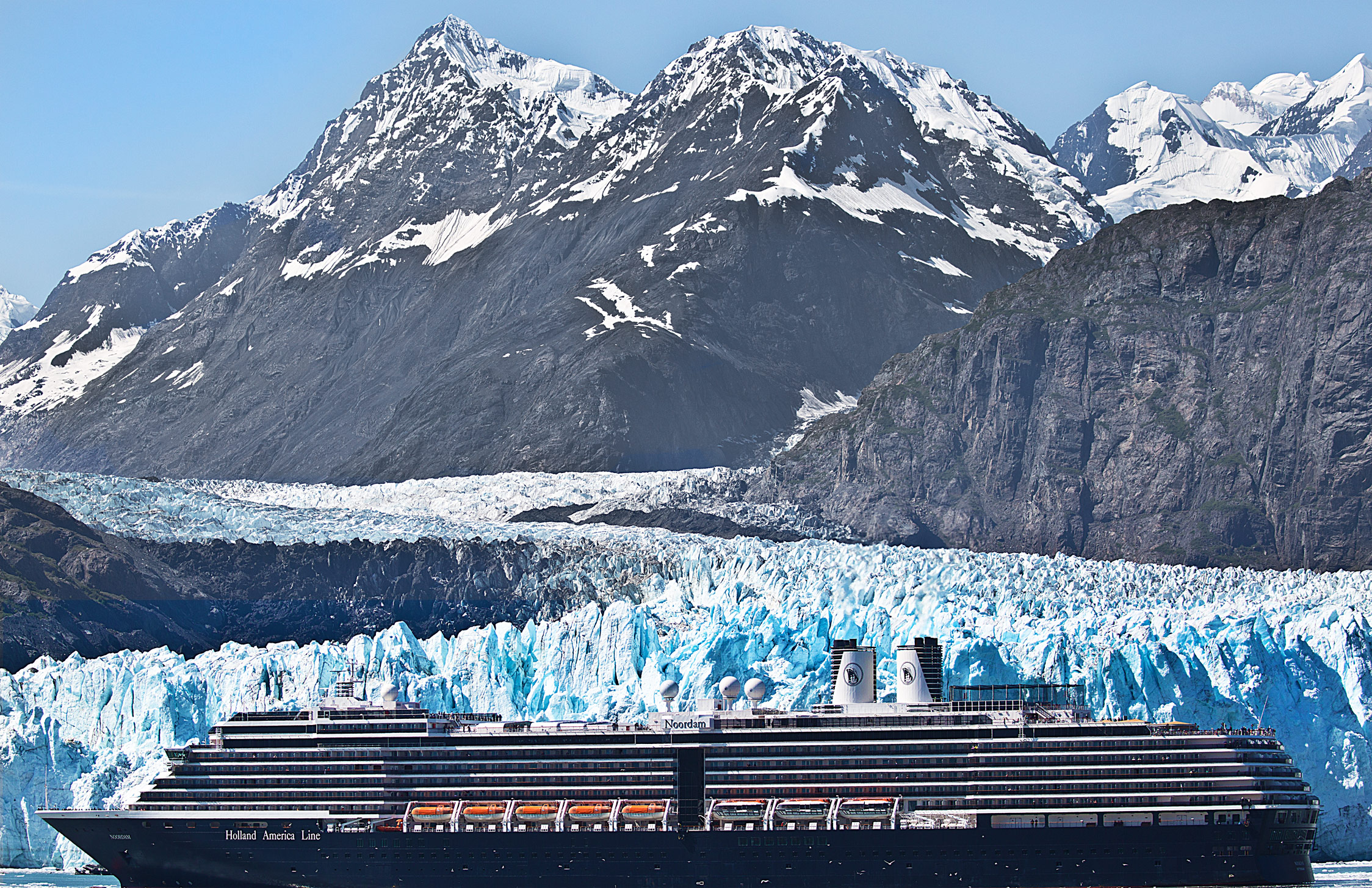 A Cruise Ship poses in front of the Margerie Glacier